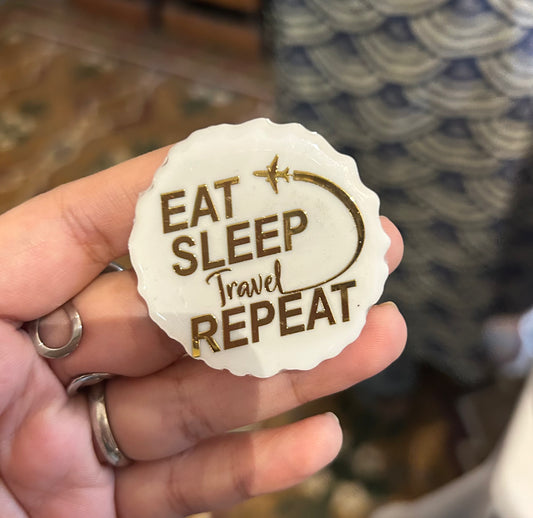 The "EAT SLEEP TRAVEL REPEAT" brooch